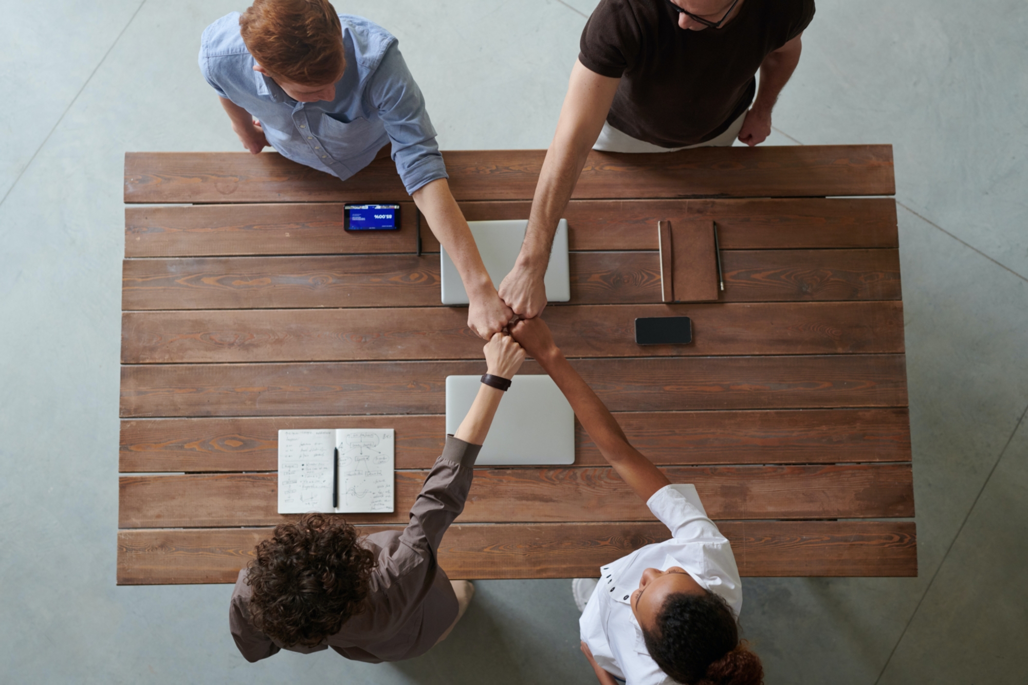 Four hands fist bumping in the center
